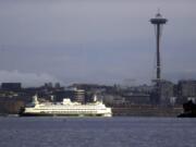 A Washington ferry heading into Elliott Bay is illuminated by the sun as the city behind remains under clouds on Dec. 27 in Seattle.