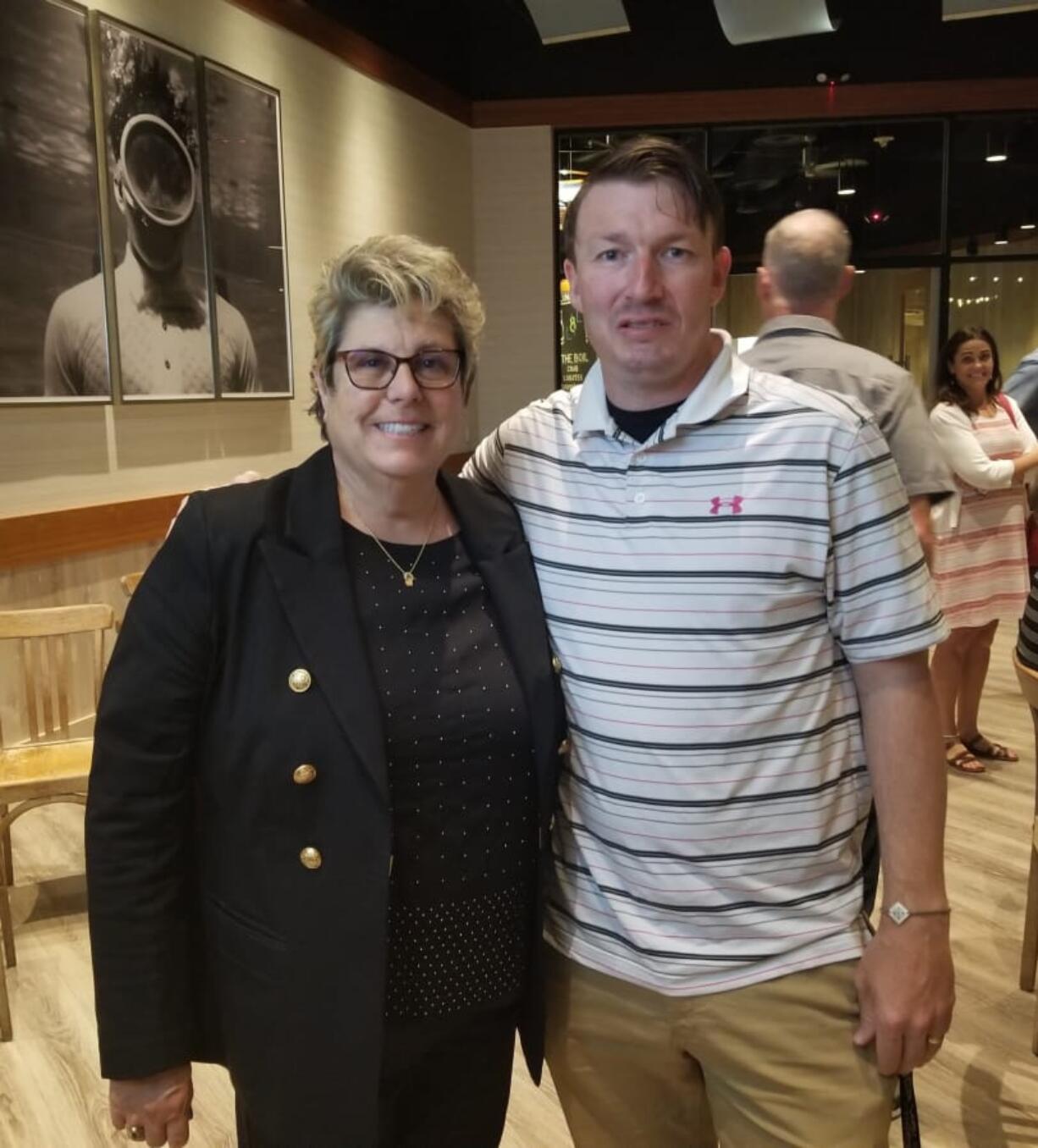 Heritage athletic director Leta Meyer poses with Heritage soccer coach Bryan Housley at an end of the school year sports awards ceremony, where Meyer was honored for her years of service. (Photo courtesy of Heritage High School).