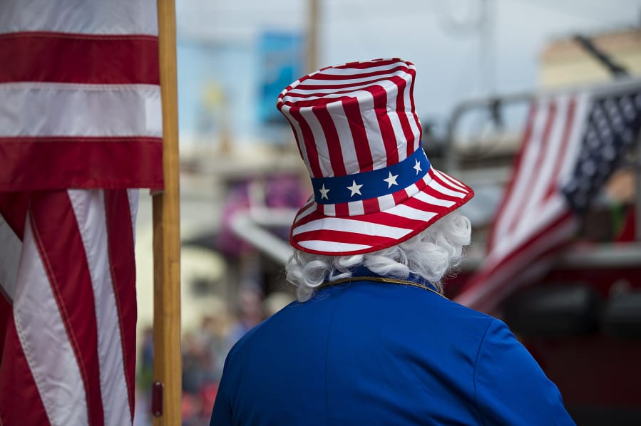 Ed Martin of Ridgefield gets into the spirit of the Fourth of July dressed as Uncle Sam as he enjoys the annual parade from his spot along Pioneer Street on Wednesday morning, July 4, 2018.(Amanda Cowan/The Columbian)