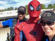 Vancouver police Cpl. Rey Reynolds and Cpl. Holly Musser pose Thursday with “Spider-Man” on the second floor of a Main Street parking garage.