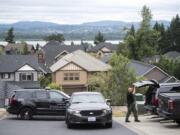 A Clark County Sheriff's Investigator searches his vehicle for gear while investigating a stabbing assault on West Lookout Ridge Drive in Washougal on Tuesday morning, June 18, 2109.