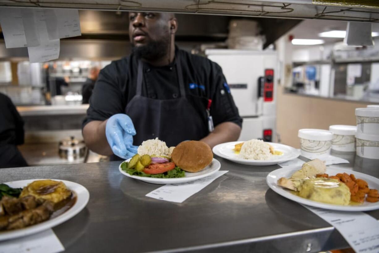 Cook Leadi Cole prepares hot meals for patients at PeaceHealth Southwest Medical Center in Vancouver. The hospital overhauled its menu recently, incorporating new nutrition trends and patient feedback.