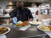 Cook Leadi Cole prepares hot meals for patients at PeaceHealth Southwest Medical Center in Vancouver. The hospital overhauled its menu recently, incorporating new nutrition trends and patient feedback.