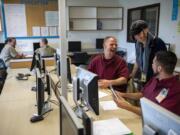 Howard Seaworth, left, and Jakkob McCallin chat with their instructor Lauren Zavrel during her GED class at Larch Corrections Center in Yacolt on May 14. Clark College recently received international recognition for its GED tutoring program at Larch, which pairs inmates preparing to take their tests with trained peer tutors. The program is now certified by the College Reading and Learning Association, which recognizes tutor-training programs across the globe.