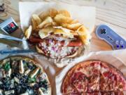 A Glowing Sea pizza, from left, a Hedgehog hot dog, and an Up With Pork pizza are pictured at Vault 31 in Vancouver.