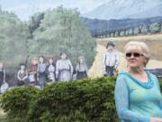 Sharon York looks past a mural of her ancestors, the Wishon family, while talking with her sisters at Orchards Plaza.