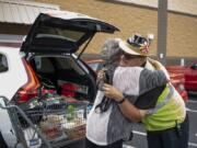 Joyce Stuck of La Center, left, embraces Ben Lemons of Battle Ground during his shift at Fred Meyer in Battle Ground on Wednesday. Lemons has worked at the store seven years, and often greets his regular customers with a hug and big smile.