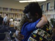 Hockinson Superintendent Sandra Yager hugs Mussè Barclay, 17, at a farewell party Monday night. Yager is leaving the district after 17 years, the last eight as superintendent. She has had an impact on plenty of students, including Barclay, who said she made him feel welcome in the area after he was adopted from Ethiopia.