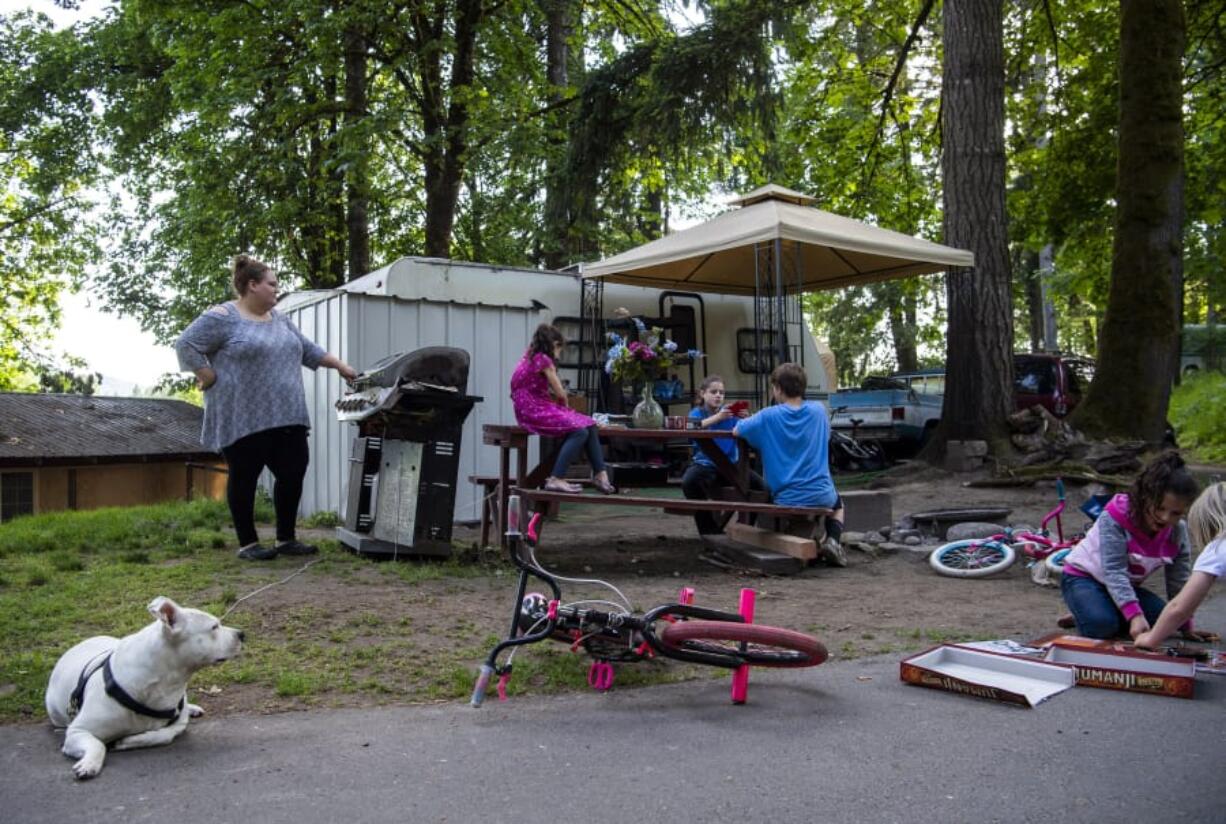 Valerie Guerra barbecues meat and vegetables for her kids outside their trailer at the Lewis River RV Park in Woodland. After being unsheltered and hotel hopping, the family decided to stay in an RV. Guerra and her husband are both working again and the family is hoping to find housing by the end of the year.