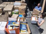 Jennifer Scott and her husband, Kevin Scott, load boxes of donated books onto a flatbed truck at their Camas home before moving the books to the Camas School District offices.