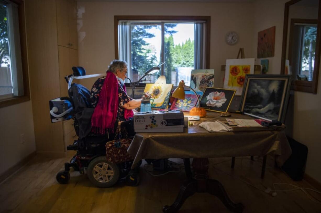 Margie Linn works on her paintings for an art show that was held Friday at Rite Choice Ventilator Speciality adult family home in Vancouver. Linn, who was diagnosed with polio as a teenager and later placed on a ventilator, feels painting is one way she stays active and independent.