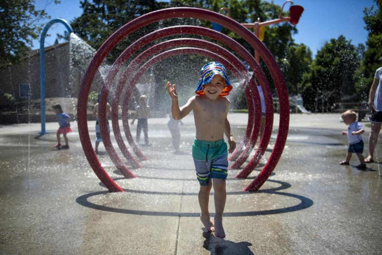 Tanner Heiss, 3, of Ridgefield plays in the water features  at Klineline Pond in Vancouver.