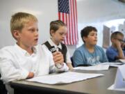 Fifth-grader Lason Spencer, left, answers a question during a mock congressional hearing Wednesday at Tukes Valley Middle School in Battle Ground. Through the We the People curriculum, students learn about history with hands-on lessons, such as Wednesday’s presentation.