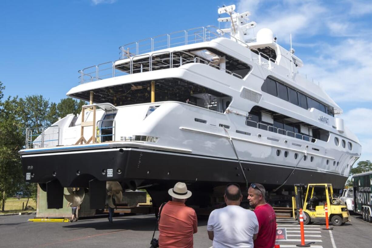 Warren Right, from left, Mike Hazelton and Chris Noce, a former Christensen Shipyards employee, watch as the Jackpot is moved from Christensen Shipyards to the launch ramp on Wednesday morning.