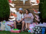 Lance and Kayla Edwards exchange a glance while opening gifts at their baby shower in Vancouver. Edwards was born without a uterus, cervix or fallopian tubes, but a uterine transplant in 2017 gave her the ability to give birth. At top, Kayla Edwards is surrounded by friends and family at her baby shower in Vancouver.