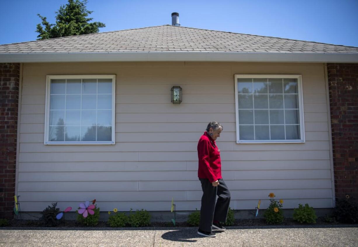 Julie Burger walks past pinwheels from the Walk to End Alzheimer’s outside her home in Vancouver. Burger was diagnosed with Alzheimer’s disease in 2016. “I have a wonderful caregiver,” Burger said, speaking of her husband, Les.