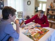 Julie Burger, right, works on a puzzle with her good friend Sue Meyer, at Burger’s home in Vancouver. Burger has Alzheimer’s disease, and incorporates activities such as puzzles into her daily routine to help keep her mind sharp. “People ask me if I’m afraid to have Alzheimer’s,” Burger said. “I don’t dwell on things.