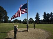 Park rangers at the Fort Vancouver National Site work to raise the American flag Friday during The Historic Trust’s 25th annual Flag Day Celebration.