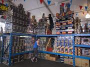 Meagan Williams, left, and Royal Gullickson of TNT Fireworks Warehouse stock up Thursday while preparing for customers in Salmon Creek. Doors open for shoppers at noon today.