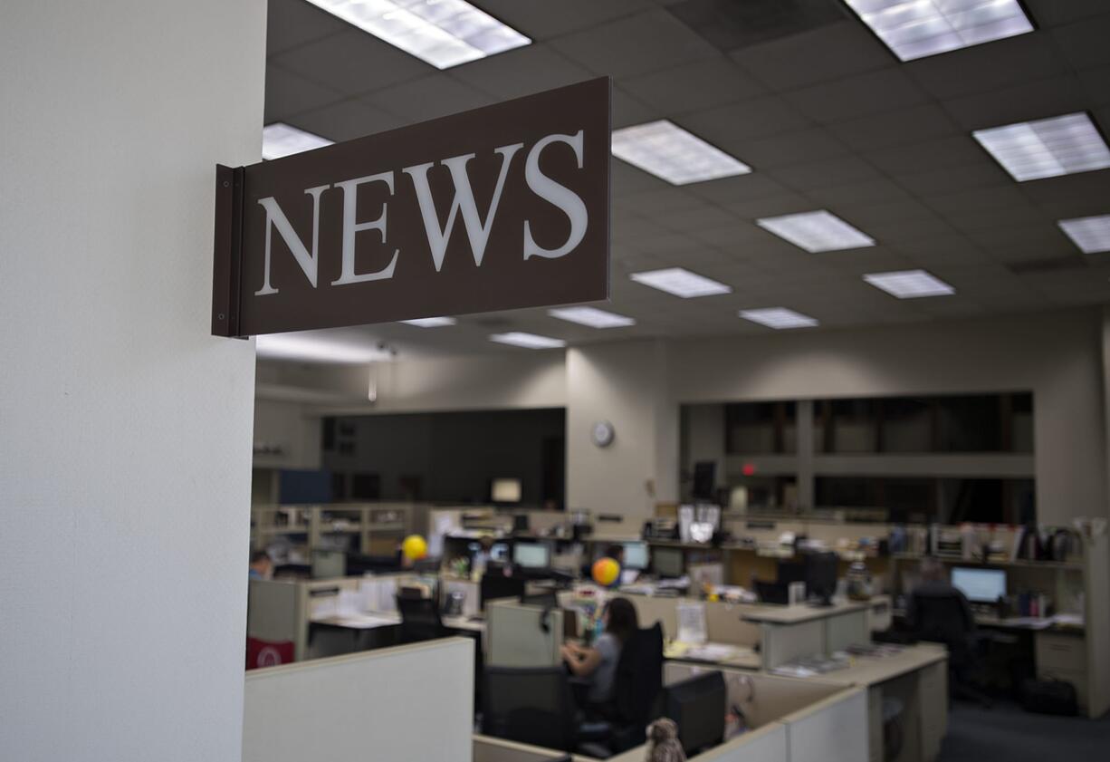 Members of The Columbian's newsroom staff work at their desks Friday afternoon in Vancouver.