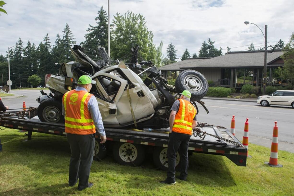 Frank Green, Washington State Department of Transportation assistant regional administrator for development and delivery, and another WSDOT employee examine the mangled remains of a WSDOT pickup during a safety and construction briefing Tuesday morning. The pickup was destroyed in a March 19 road work-zone crash on state Highway 3 in Northwest Washington.