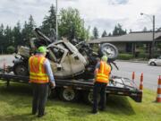 Frank Green, Washington State Department of Transportation assistant regional administrator for development and delivery, and another WSDOT employee examine the mangled remains of a WSDOT pickup during a safety and construction briefing Tuesday morning. The pickup was destroyed in a March 19 road work-zone crash on state Highway 3 in Northwest Washington.