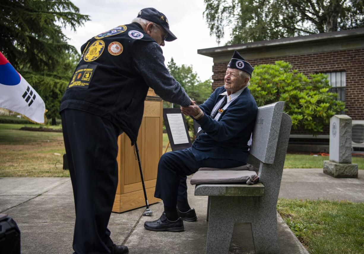 Former Cmdr. Ed Barnes, left, and Cmdr. Ralph Hager, right, greet one another during the remembrance ceremony for the 69th anniversary of the Korean War at the Clark County Korean War monument on the Vancouver Veterans Affairs campus on Tuesday, June 25, 2019.