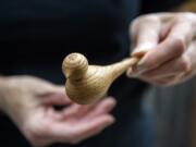 Clark County woodturner Kathleen Duncan shows a little wooden bird that she just finished turning and assembling at her home workshop in Mount Vista.