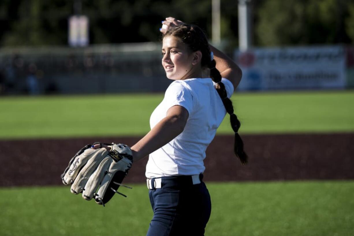 Elizabeth Peery throws out the first pitch at the Ridgefield Raptors game Friday, where she was honored for making the finals of the national Pitch, Hit & Run competition.