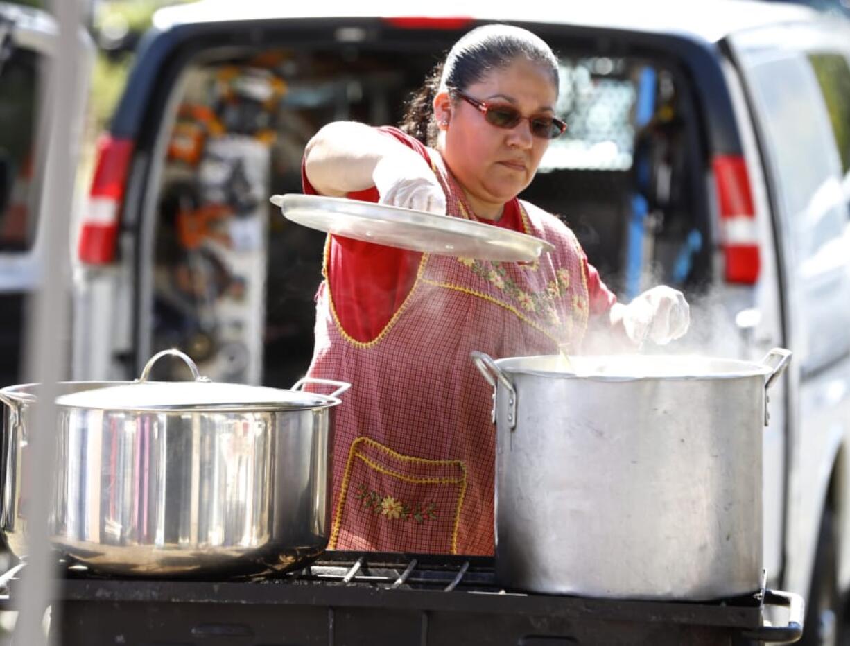 Carmen Luna of Vancouver serves up tamales Saturday at the Southwest Washington Tamale Festival, which grew in its second year by doubling the number of food vendors and bringing in vendors selling other items.