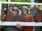 Dan Colwell, left, and Lorraine Colwell show off their purchase Sunday as they leave the annual Clark County Recycled Arts Festival at Esther Short Park in Vancouver.