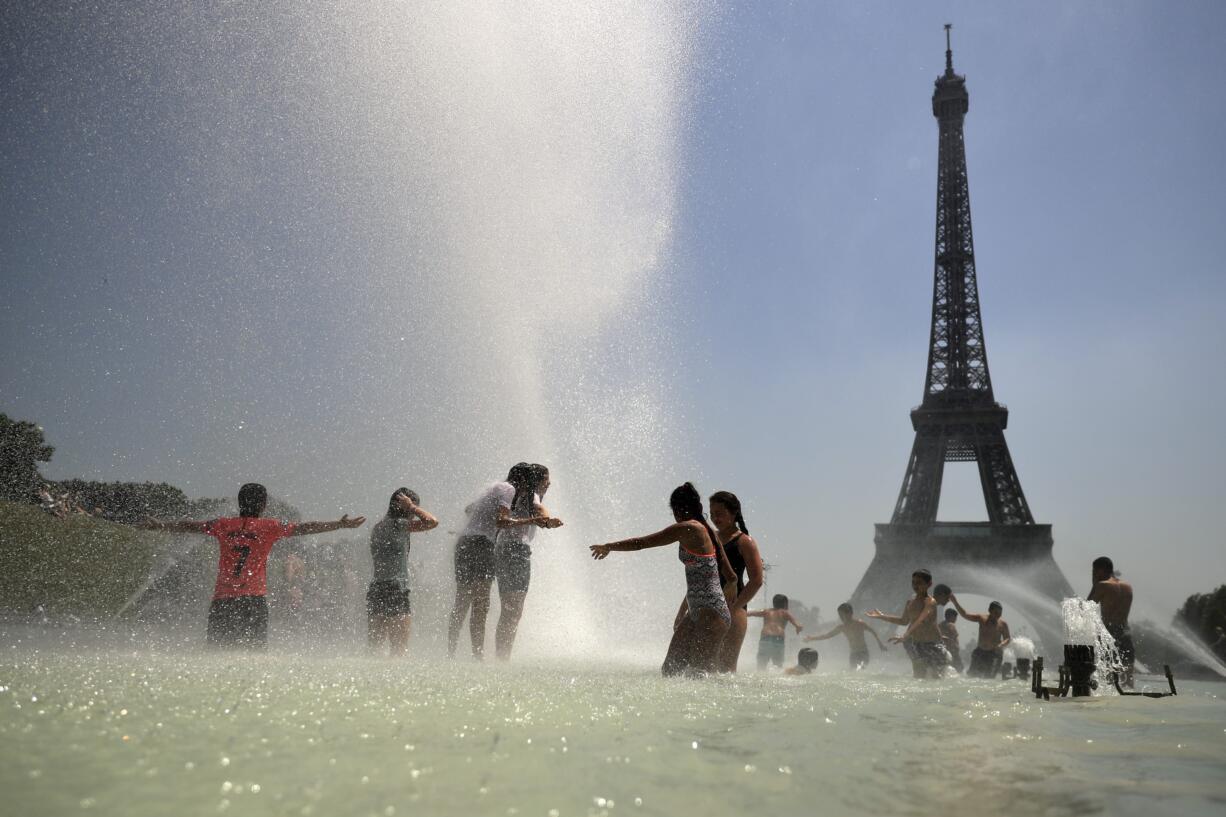 Youngsters cool off at the Trocadero public fountain in Paris, Wednesday, June 26, 2019. High temperatures are expected to go up to 39 degrees Celsius (102 Fahrenheit) in the Paris area later this week and bake much of the country, from the Pyrenees in the southwest to the German border in the northeast.