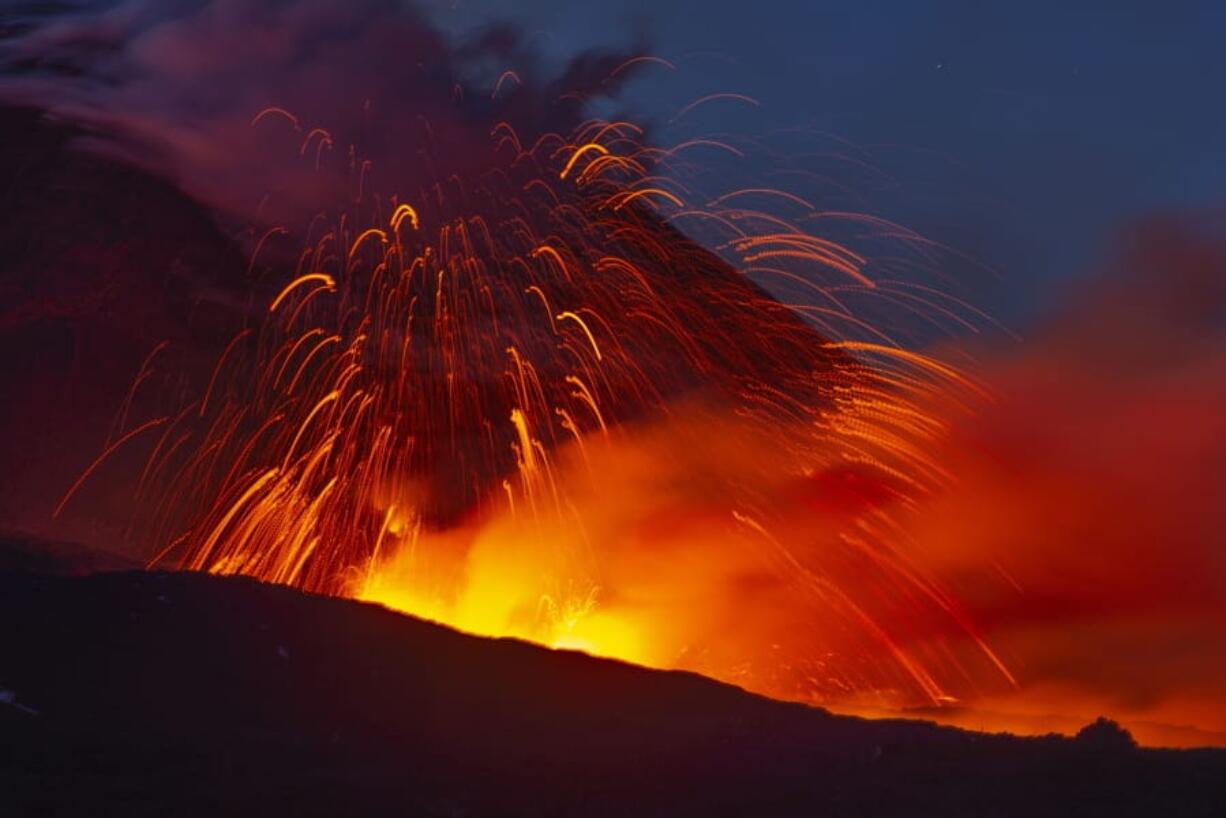 Mount Etna spews lava during an eruption Thursday in Sicily. The volcano has roared back into action, sending up plumes of ash and spewing lava.