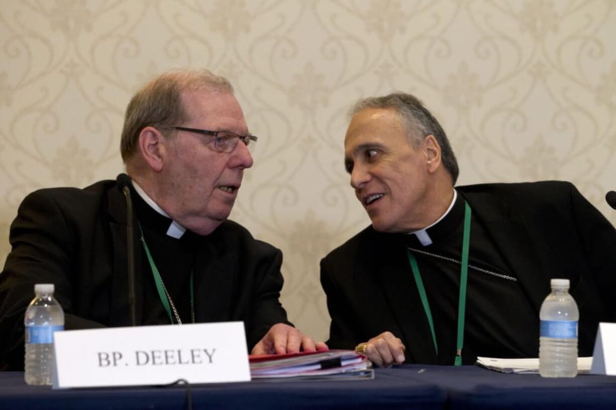 Bishop Robert Deeley of Portland Bishop of Diocese of Portland, left, speaks with Cardinal Daniel DiNardo of the Archdiocese of Galveston-Houston, speaks during a news conference at the United States Conference of Catholic Bishops (USCCB), 2019 Spring meetings in Baltimore, Md., Tuesday, Jun 11, 2019.