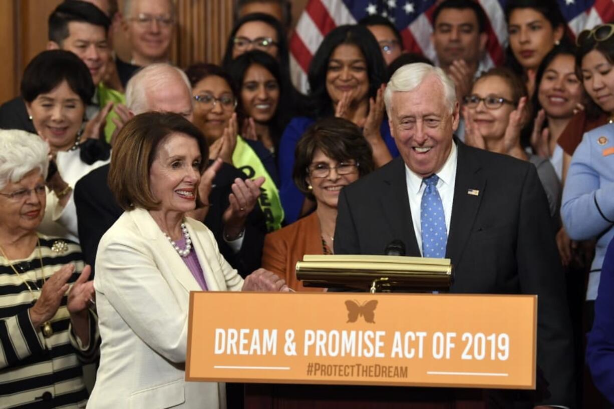 House Speaker Nancy Pelosi of California, front left, shakes hands with House Minority Whip Steny Hoyer, D-Md., during an event Tuesday on Capitol Hill regarding the American Dream and Promise Act.