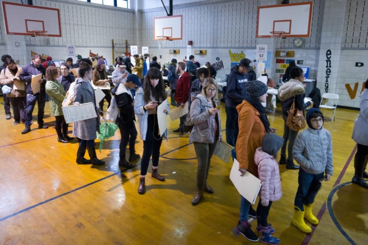 FILE - In this Tuesday, Nov. 6, 2018, file photo, voters stand in line to cast their ballots at P.S. 22, in the Prospect Heights neighborhood in the Brooklyn borough of New York. An effort by Democrats to implement broad reforms to the nation’s voting process has stalled in the U.S. Senate, but some states are moving forward to expand access through early voting, same-day voter registration and other measures ahead of 2020. The biggest success for voting rights advocates so far is New York, which had been one of a dozen states not offering some form of early voting.