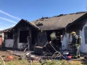 Firefighters inspect a house in Vancouver's Northwest neighborhood after it was devastated by fire June 2. The fire killed one dog.