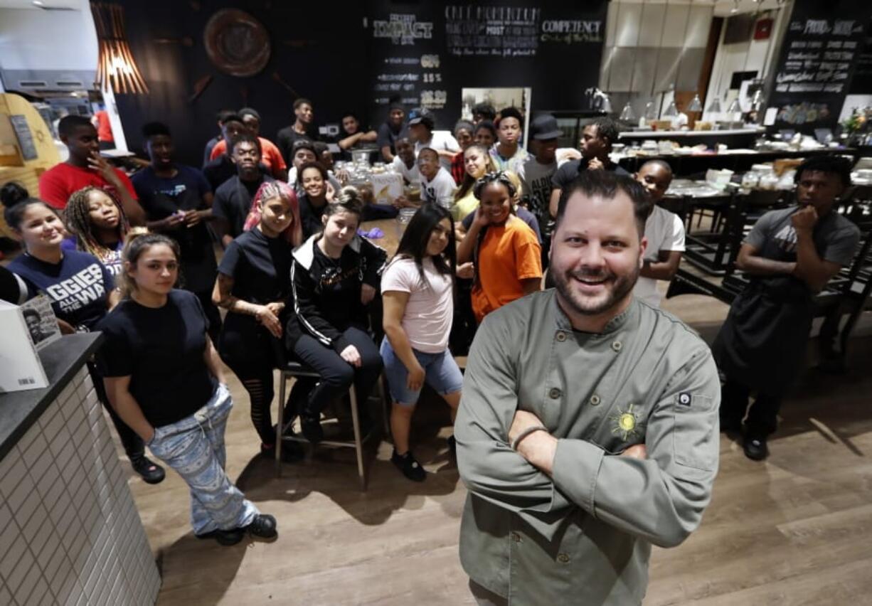 Chad Houser, founder and executive chef at Cafe Momentum, poses for a photograph June 4 with members of his staff inside the cafe in Dallas.