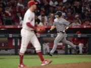 Seattle Mariners' Tom Murphy, right, rounds third after hitting a three-run home run off Los Angeles Angels starting pitcher Andrew Heaney, foregound, during the sixth inning of a baseball game Friday, June 7, 2019, in Anaheim, Calif. (AP Photo/Mark J.