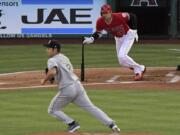 Los Angeles Angels’ Shohei Ohtani, right, runs to first for a single as Seattle Mariners starting pitcher Yusei Kikuchi runs to back up the first baseman during the first inning of a baseball game Saturday, June 8, 2019, in Anaheim, Calif. (AP Photo/Mark J.