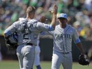 Seattle Mariners pitcher Roenis Elias, right, celebrates with Tom Murphy (2) after their win over the Oakland Athletics in a baseball game Sunday, June 16, 2019, in Oakland, Calif.