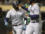 Seattle Mariners’ Omar Narvaez, left, celebrates with Domingo Santana after hitting a two-run home run off Oakland Athletics’ Wei-Chung Wang during the seventh inning of a baseball game Friday, June 14, 2019, in Oakland, Calif.