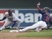 Minnesota Twins’ Jorge Polanco slides safely into second base against Seattle Mariners’ Dee Gordon with a double during the first inning of a baseball game Tuesday, June 11, 2019, in Minneapolis.