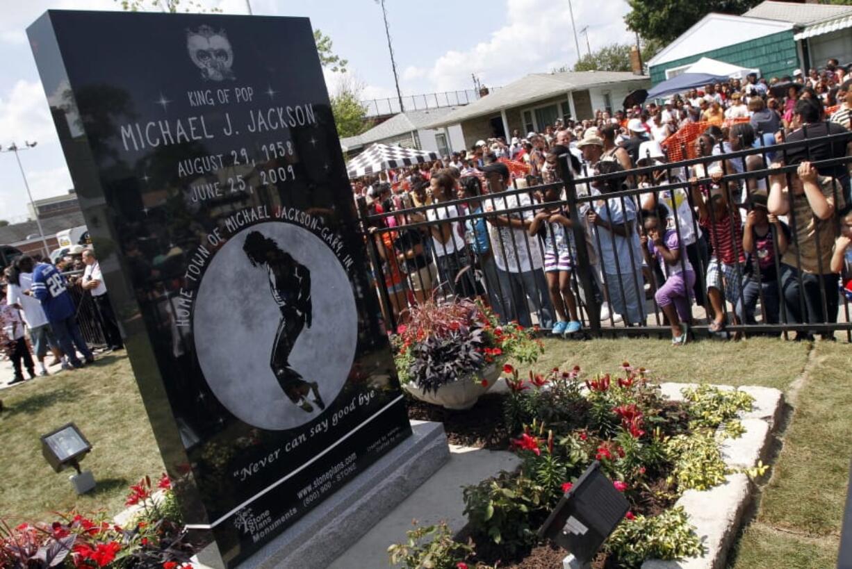 FILE - In this June 25, 2010 file photo, Michael Jackson fans gather around a monument that was unveiled in Gary, Ind., on the first anniversary of the pop icon’s death. As the 10th anniversary of Jackson’s death approaches, experts say his music legacy is still going strong despite the documentary’s detailed abuse allegations.