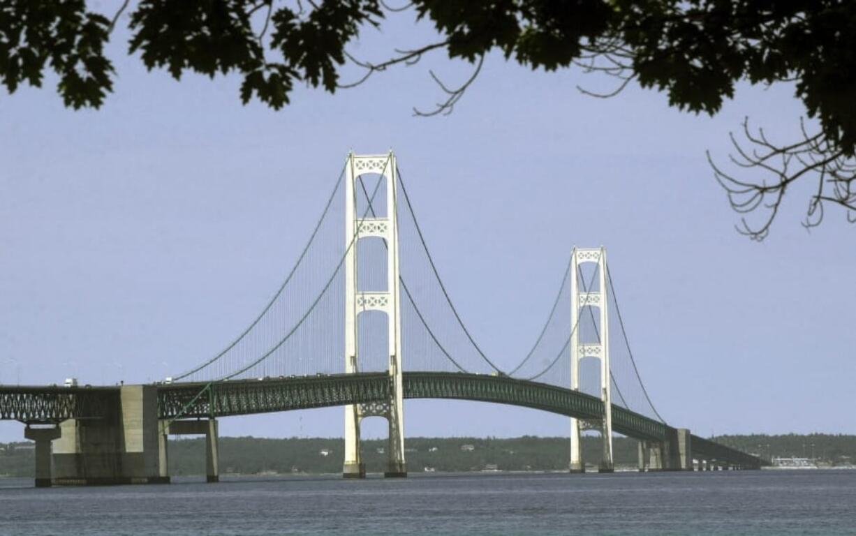 FILE - This July 19, 2002, file photo, shows the Mackinac Bridge that spans the Straits of Mackinac from Mackinaw City, Mich. Enbridge Inc. said Monday, June, 17, 2019, it’s moving ahead with collection of rock and soil samples in the Straits of Mackinac while preparing for a court battle with Michigan’s governor over a planned oil pipeline tunnel there. The Canadian company, which has been drilling into the ground on the south side of the channel linking Lakes Huron and Michigan, said it will begin boring into the lakebed this week from a barge in shallow water.