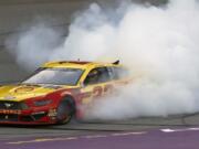 Joey Logano celebrates with a burnout after winning a NASCAR Cup Series auto race at Michigan International Speedway, Monday, June 10, 2019, in Brooklyn, Mich.