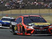 Martin Truex Jr., right, leads Chase Elliott through a turn during a NASCAR Sprint Cup Series auto race Sunday, June 23, 2019, in Sonoma, Calif.