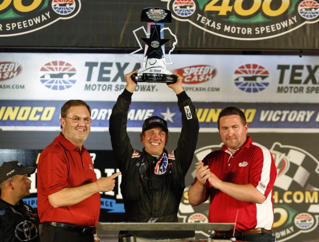 Greg Biffle raises the trophy after winning the NASCAR Truck Series auto race at Texas Motor Speedway in Fort Worth, Texas, Friday, June 7, 2019.