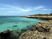 In this April 2008 file photo, crystal clear water meets the shore in Aruba. Aruba offers a sun-drenched Caribbean escape outside the hurricane belt, making this island retreat an irresistible option for late-summer travelers.