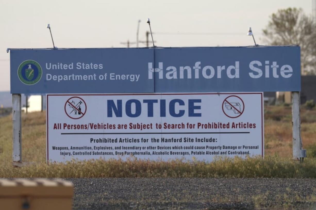 FILE - In this May 9, 2017, file photo, signs are posted at an entrance to the Hanford Nuclear Reservation in Richland, Wash.The state of Washington believes the federal government is unlikely to meet legal deadlines for emptying underground tanks holding radioactive waste at Hanford. The state Department of Ecology says it is prepared to take the U.S. Department of Energy back to federal court to get the cleanup back on track.